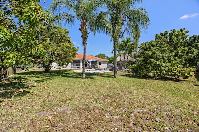 view of yard with a fenced in pool, a lanai, and fence