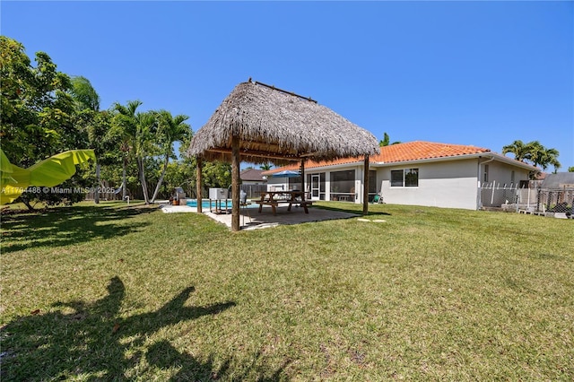 view of yard featuring fence, a gazebo, a patio area, and an outdoor pool