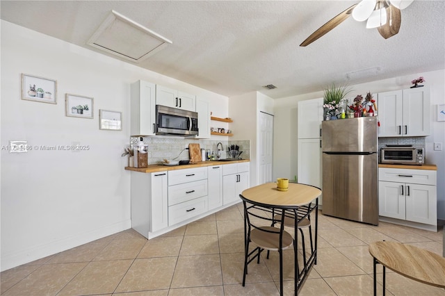 kitchen featuring a sink, appliances with stainless steel finishes, backsplash, and a toaster