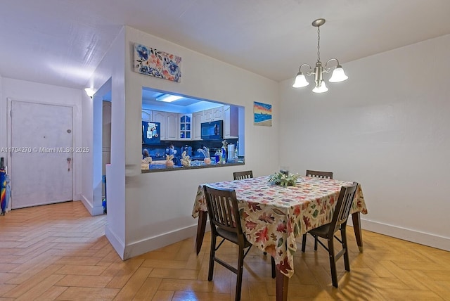 dining room featuring baseboards and a notable chandelier
