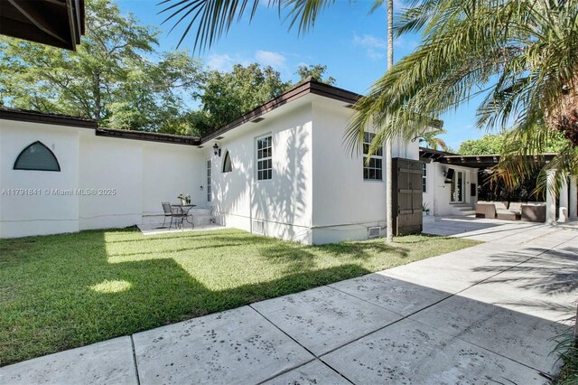 1161 Sunset Dr, Coral Gables, FL 33143 - view of property exterior featuring a patio, a lawn, and entry steps