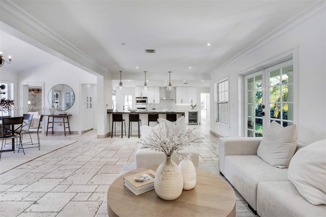 1161 Sunset Dr, Coral Gables, FL 33143 - living area featuring beverage cooler, crown molding, stone tile flooring, recessed lighting, and a chandelier