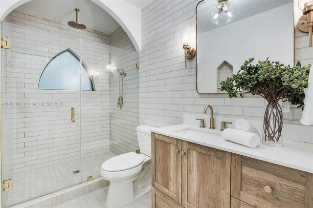 1161 Sunset Dr, Coral Gables, FL 33143 - bathroom with toilet, a shower stall, vanity, tasteful backsplash, and tile walls