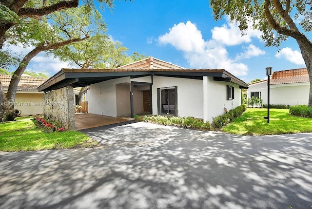 3501 Keyser Ave Unit 43, Hollywood, FL 33021 - view of front of property featuring stucco siding, an attached carport, a front lawn, and aphalt driveway