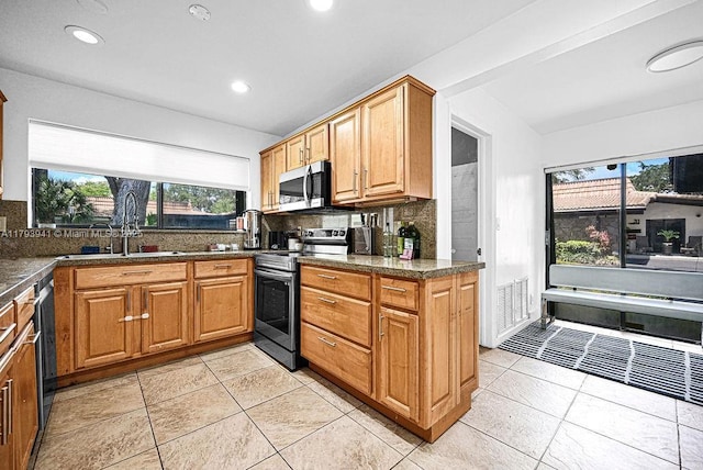 3501 Keyser Ave Unit 43, Hollywood, FL 33021 - kitchen featuring a sink, appliances with stainless steel finishes, backsplash, and dark countertops