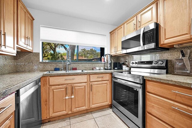 3501 Keyser Ave Unit 43, Hollywood, FL 33021 - kitchen featuring a sink, appliances with stainless steel finishes, decorative backsplash, and light tile patterned floors