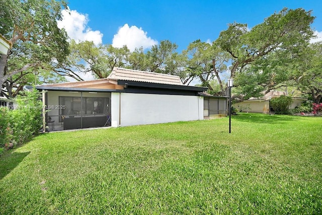 3501 Keyser Ave Unit 43, Hollywood, FL 33021 - rear view of property featuring a sunroom, a lawn, stucco siding, and a tiled roof