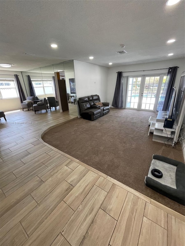 8588 NW 27th Dr, Coral Springs, FL 33065 - living room with french doors, a textured ceiling, visible vents, wood finish floors, and recessed lighting