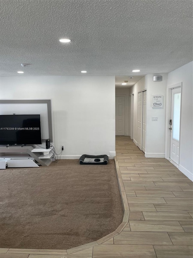 8588 NW 27th Dr, Coral Springs, FL 33065 - workout room with wood tiled floor, baseboards, recessed lighting, and a textured ceiling