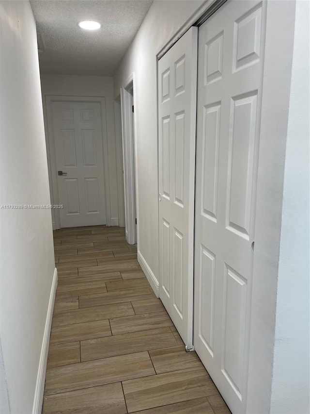 8588 NW 27th Dr, Coral Springs, FL 33065 - hall with baseboards, light wood finished floors, and a textured ceiling