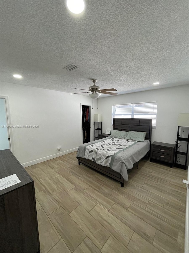 8588 NW 27th Dr, Coral Springs, FL 33065 - bedroom with visible vents, baseboards, ceiling fan, wood finish floors, and a textured ceiling
