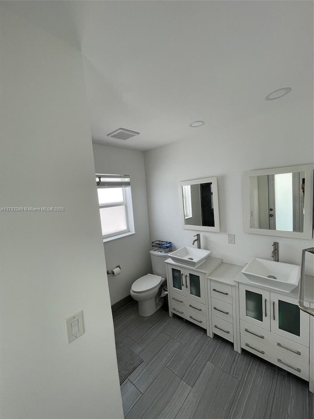 8588 NW 27th Dr, Coral Springs, FL 33065 - bathroom with double vanity, a sink, visible vents, and toilet