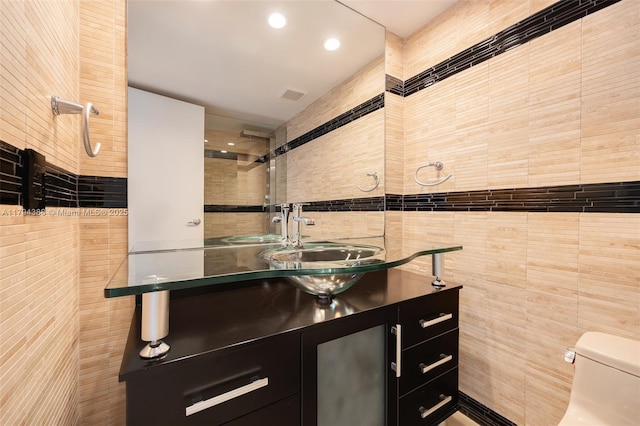 bathroom with tile walls, toilet, recessed lighting, and vanity