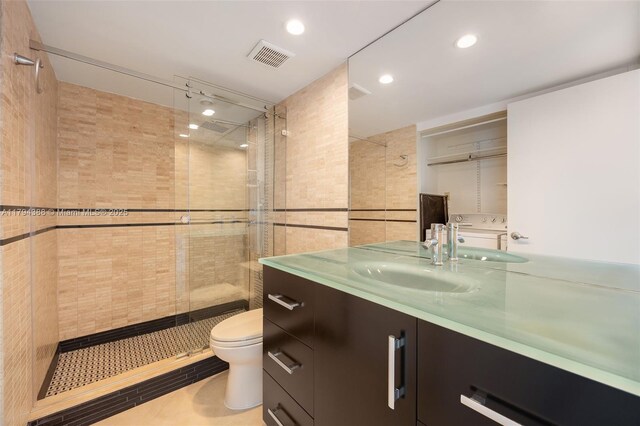 1600 S Bayshore Ln Unit 8D, Coconut Grove, FL 33133 - bathroom with washer / clothes dryer, toilet, a shower stall, vanity, and tile patterned floors