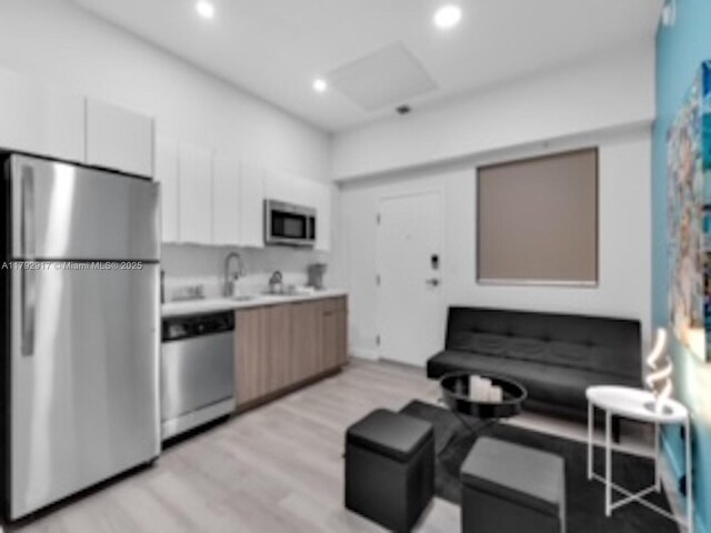136 NW 26th St Unit 503, Miami, FL 33127 - kitchen featuring light wood-type flooring, light countertops, white cabinetry, recessed lighting, and stainless steel appliances