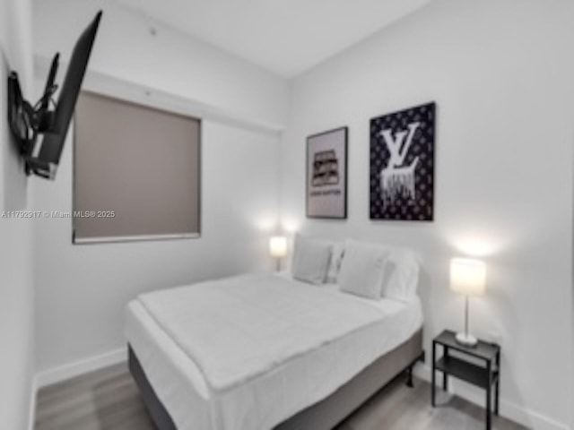136 NW 26th St Unit 503, Miami, FL 33127 - bedroom featuring baseboards and wood finished floors