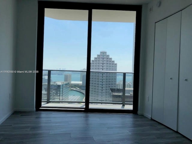 801 S Miami Ave Unit 2505, Miami, FL 33130 - unfurnished bedroom with expansive windows, a city view, wood finished floors, and multiple windows