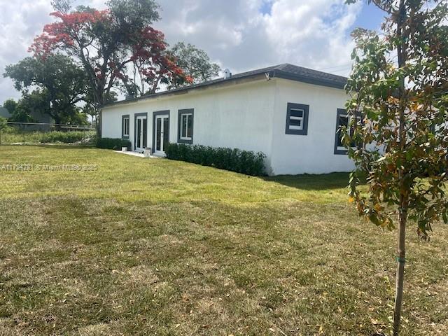 11870 SW 220th St, Miami, FL 33170 - back of house featuring stucco siding and a lawn