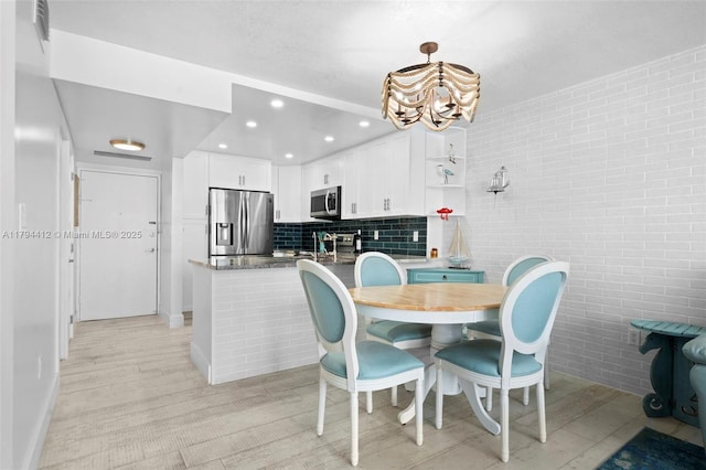 dining room with an inviting chandelier, recessed lighting, and baseboards