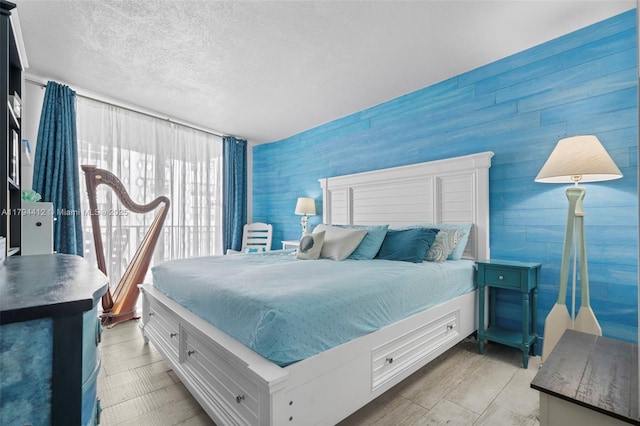 bedroom featuring wooden walls and a textured ceiling