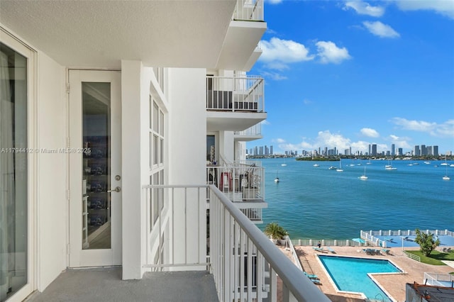 balcony featuring a water view and a city view
