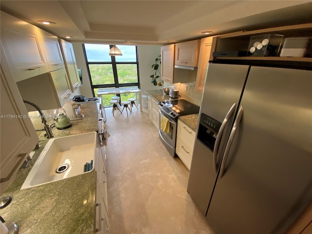 kitchen featuring stone countertops, a sink, a wall of windows, and stainless steel appliances