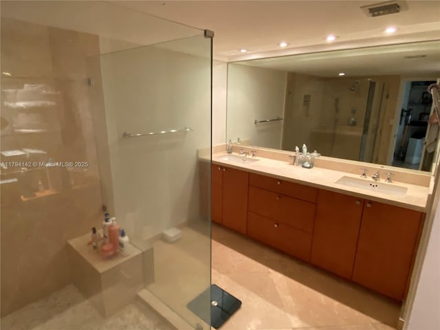full bathroom with double vanity, a sink, a stall shower, and recessed lighting