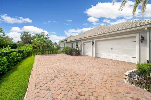5202 S Sterling Ranch Cir, Davie, FL 33314 - exterior space featuring an attached garage, decorative driveway, stucco siding, and fence
