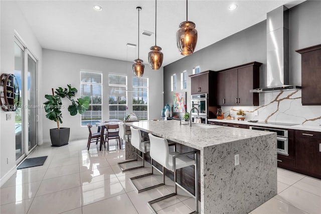 5202 S Sterling Ranch Cir, Davie, FL 33314 - kitchen featuring decorative backsplash, electric stovetop, dark brown cabinets, a sink, and wall chimney exhaust hood