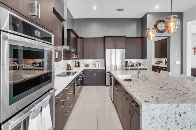5202 S Sterling Ranch Cir, Davie, FL 33314 - kitchen with a kitchen island with sink, visible vents, dark brown cabinets, a sink, and light tile patterned floors