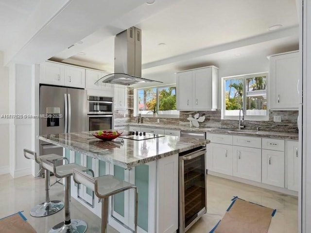 416 N Rainbow Dr, Hollywood, FL 33021 - kitchen featuring beverage cooler, island exhaust hood, stainless steel appliances, and decorative backsplash