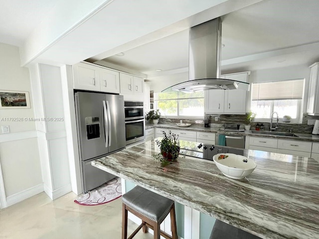 416 N Rainbow Dr, Hollywood, FL 33021 - kitchen with appliances with stainless steel finishes, island exhaust hood, healthy amount of natural light, and dark stone countertops