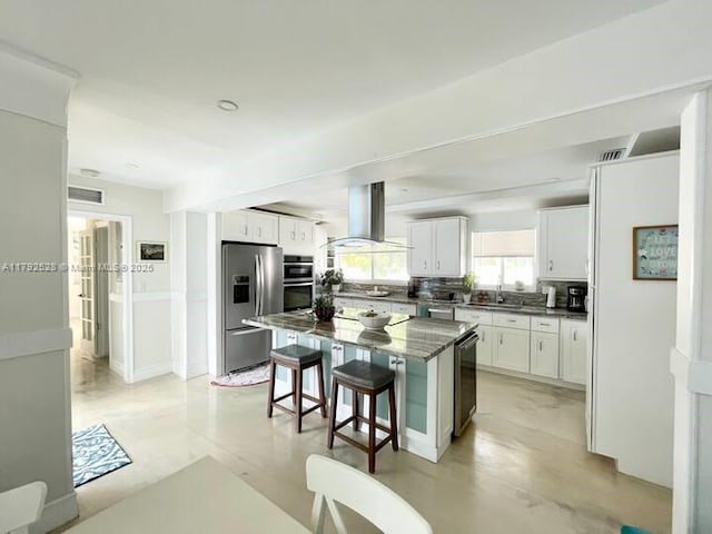 416 N Rainbow Dr, Hollywood, FL 33021 - kitchen featuring range hood, stainless steel appliances, a kitchen bar, white cabinetry, and a center island
