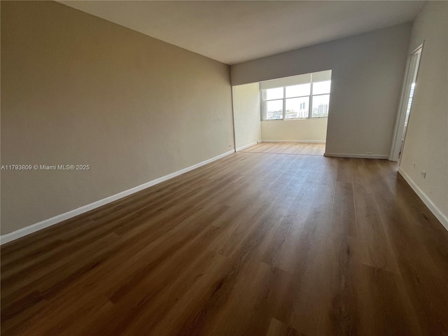 3 Island Ave Unit 08A, Miami Beach, FL 33139 - empty room featuring dark wood-style flooring and baseboards