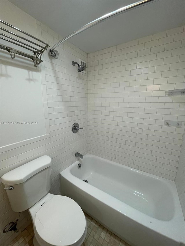 bathroom featuring toilet, shower / bath combination, tile walls, and tile patterned floors