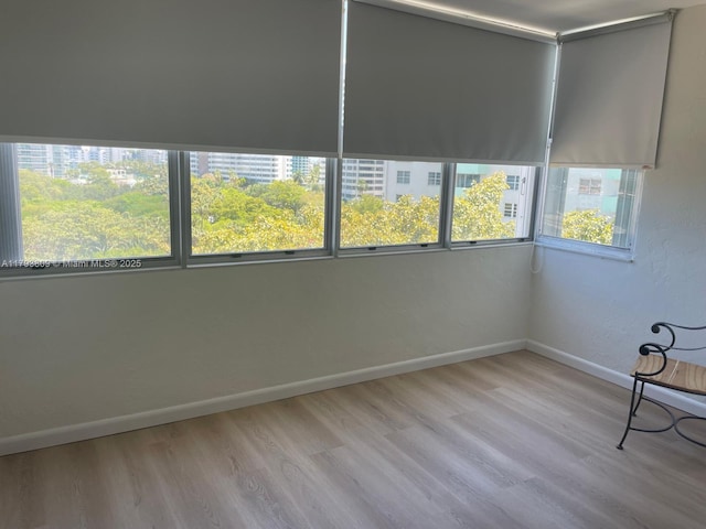 spare room featuring baseboards and light wood-style flooring