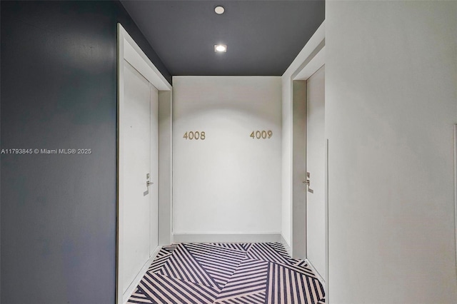 corridor with carpet floors, baseboards, and recessed lighting