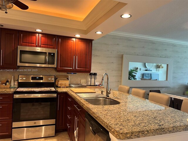 kitchen featuring recessed lighting, appliances with stainless steel finishes, ornamental molding, and a peninsula