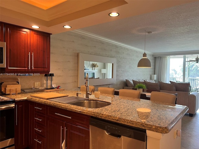 kitchen with tile patterned flooring, a sink, open floor plan, and stainless steel appliances