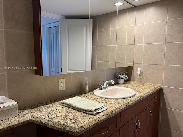 bathroom with vanity, tile walls, and backsplash