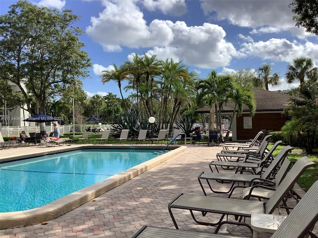 pool featuring fence and a patio area
