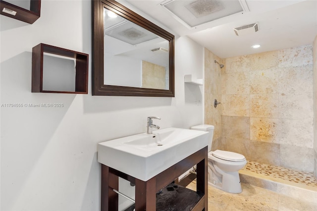 full bath with visible vents, vanity, toilet, and tiled shower