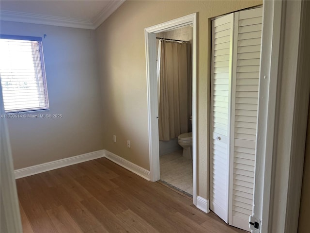 8515 SW 152nd Ave Unit 284, Miami, FL 33193 - unfurnished bedroom featuring baseboards, ornamental molding, wood finished floors, and ensuite bath