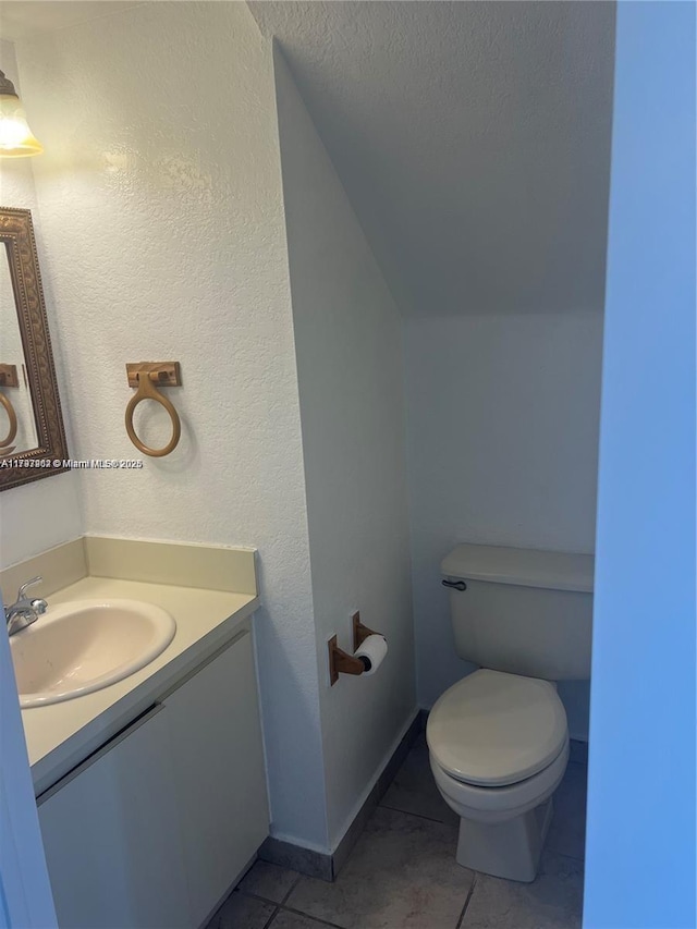 8515 SW 152nd Ave Unit 284, Miami, FL 33193 - half bath with vanity, tile patterned flooring, vaulted ceiling, and toilet