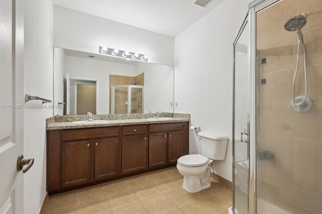 bathroom featuring a sink, tile patterned floors, a shower stall, and double vanity
