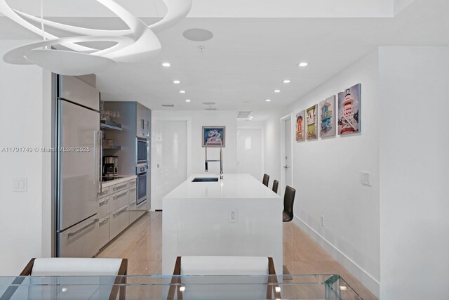 3801 Collins Ave Unit 703, Miami Beach, FL 33140 - kitchen featuring a sink, light countertops, a kitchen island with sink, recessed lighting, and high quality fridge