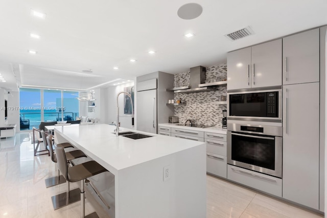 3801 Collins Ave Unit 703, Miami Beach, FL 33140 - kitchen with visible vents, wall chimney exhaust hood, tasteful backsplash, black appliances, and gray cabinetry