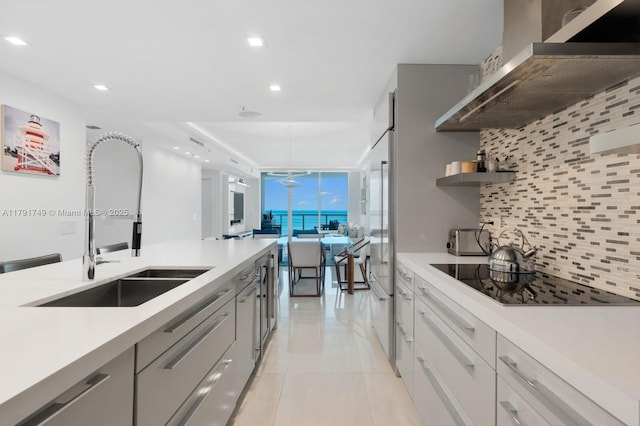 3801 Collins Ave Unit 703, Miami Beach, FL 33140 - kitchen featuring backsplash, a sink, black electric stovetop, recessed lighting, and extractor fan