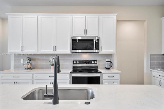 kitchen featuring white cabinets, appliances with stainless steel finishes, and a sink