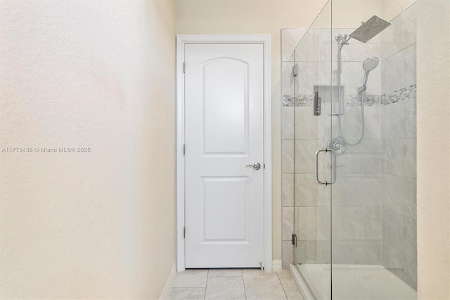 bathroom featuring baseboards, a shower stall, and tile patterned flooring